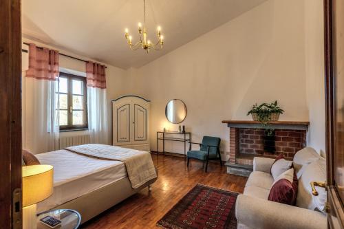 een slaapkamer met een bed, een bank en een open haard bij AwesHomeitaly - Villa San Martino in Croce del Magno