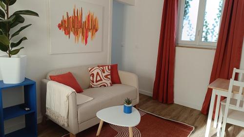 a living room with a couch and a table at L'Escale Songeonnaise in Songeons