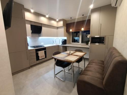 a small kitchen with a table and a couch at 2к шикарний люкс! in Khmelʼnytsʼkyy