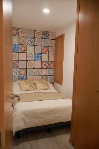 a bedroom with two beds and a tile wall at VIELA Guest House T1 in Barcelos