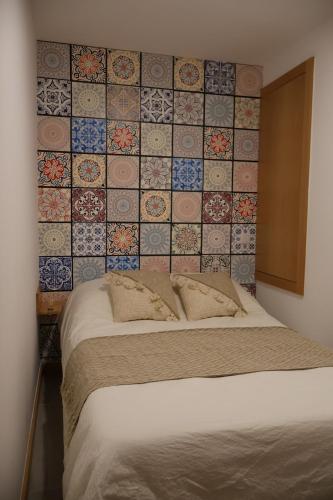 1 cama en un dormitorio con una pared de azulejos en VIELA Guest House T1, en Barcelos