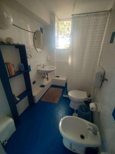 a bathroom with a white toilet and a sink at Appartamenti Jeko in Lampedusa