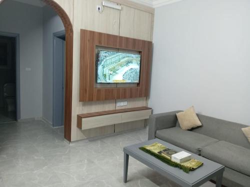 Una sala de estar con un sofá y un televisor. en فخامة مسرة لشقق المخدومة, en Taif