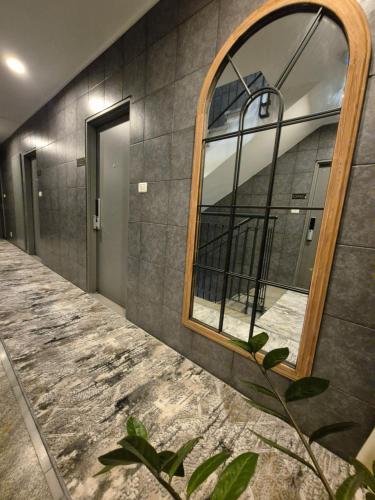 a mirror on a wall next to a hallway at DovrInn Boutique ApartHotel DownTown in Haifa