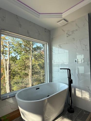 a white bath tub in a bathroom with a window at Unique 3-bed Lakefront Container Home in National City