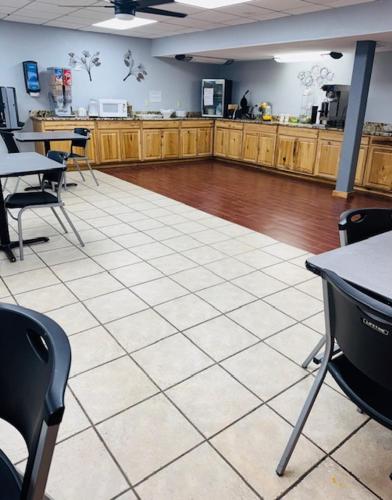 Plaza Inn في بيغ سبرينغ: غرفة بطاولات وكراسي وكافتريا