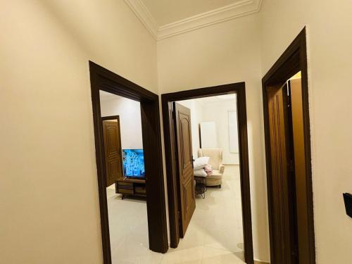 a hallway with three mirrors and a television in a room at Apartment in Al Faisaliah شقة بغرفة نوم وصالة دخول ذاتي برمز سري in Jeddah