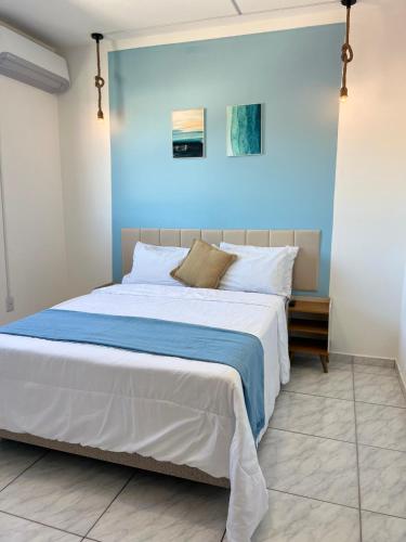 ein Schlafzimmer mit einem großen Bett mit einer blauen Wand in der Unterkunft Lindo apartamento! 2 quartos com suíte, churrasqueira, garagem in Florianópolis
