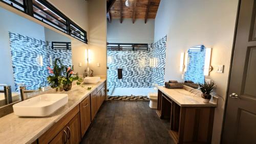 a large bathroom with two sinks and a shower at Cayo Casa Grande Modular Villa with Pool, Gym & Valley Views in Santa Elena