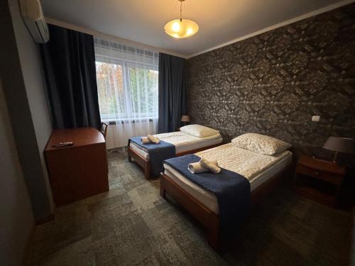 a hotel room with two beds and a window at Gościniec Witomino in Gdynia