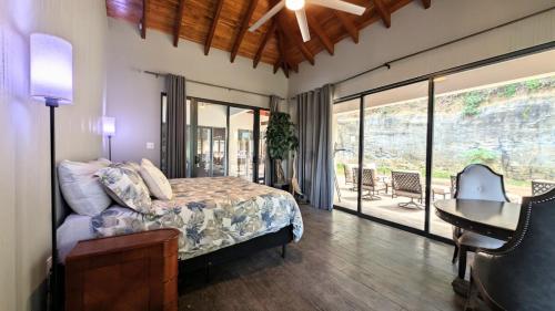 a bedroom with a bed and a table and a desk at Cayo Casa Grande Modular Villa with Pool, Gym & Valley Views in Santa Elena