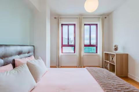 Un dormitorio con una cama blanca y dos ventanas. en Refugio dos Beijinhos, en Leça da Palmeira