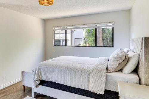 een slaapkamer met een bed en een raam bij Steps to Sand and Surf! Snowbird Haven in Malibu in Solromar