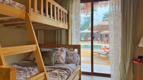 a bedroom with bunk beds and a patio with a pool at Rosa del Sol - Entire Private Villa with Pool in Calasiao