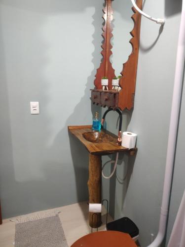 a bathroom with a sink and a mirror at Cabana Beija Flor, a nest in nature in Tijucas