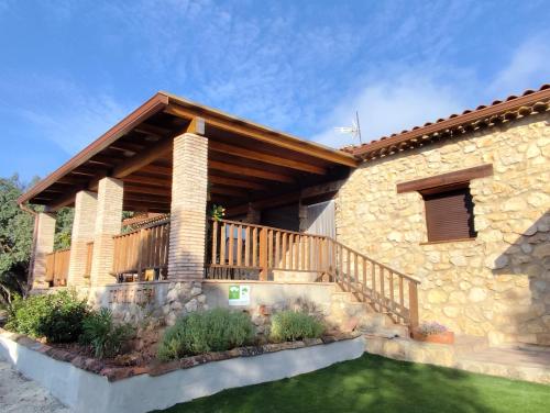 a stone house with a deck and a yard at CR La Carrasca in Riópar