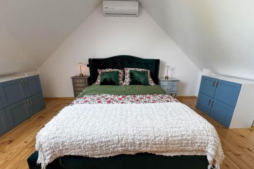 a bedroom with a large bed with two blue cabinets at Siedlisko 3 Stodoły Bałtów - SPA w naturze in Bałtów
