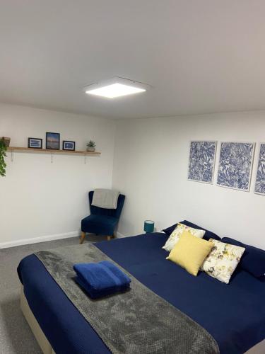 a bedroom with a bed and a chair at Wyndham studio in Uphill