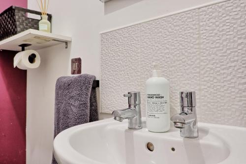 a bathroom sink with a bottle of soap on it at Spacious 4BR Townhouse, Sleeps 9, Fast WIFI, FREE PARKING, Contractor friendly in Colchester
