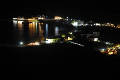 a view of a city at night with the water at Miraluna Aparthotel in Lefkos Karpathou