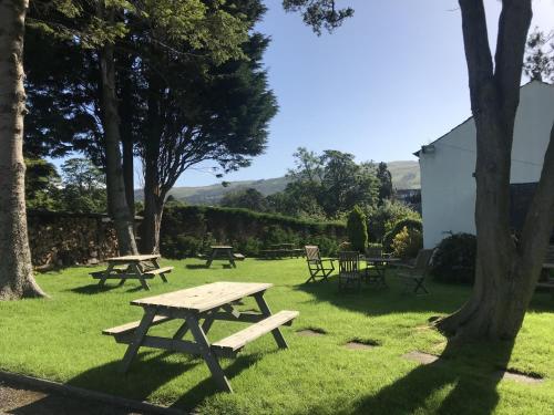 eine Gruppe von Picknicktischen und Stühlen im Gras in der Unterkunft Pheasant Inn in Kirkby Lonsdale