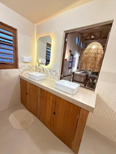 a bathroom with two sinks and a large mirror at Matteo & Matteo Hostel Boutique in Pipa