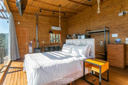 Refúgio na Serra c/ Vista Linda VST016 في São Paulo dos Pinhais: غرفة نوم بها سرير وجدار خشبي