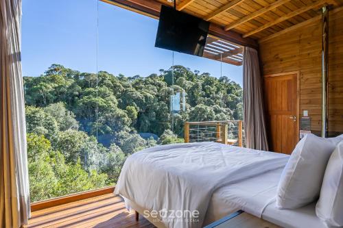 a bedroom with a bed and a large window at Refúgio na Serra c/ Vista Linda VST016 in São Paulo dos Pinhais