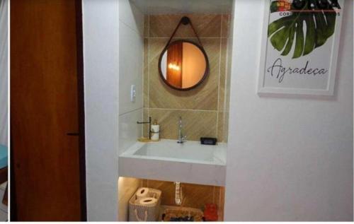 a bathroom with a sink and a mirror at Chalé aconchegante in Gravatá