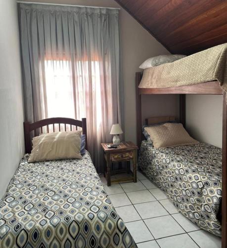 a bedroom with two bunk beds and a window at Chalé aconchegante in Gravatá