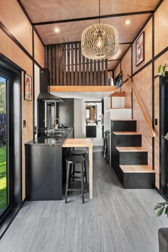 a kitchen and dining area of a tiny house at Tiny Home Escape w Sauna and Plunge in Whangarei