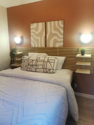 a bedroom with a large white bed with two lights at Beautiful cocooning appartement in La Chapelle-sur-Erdre