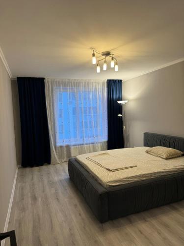 切尔卡瑟Стильні апартаменти з двома окремими спальнями з панорамним видом на Дніпро!的一间卧室，里面有一张床和一扇大窗户。