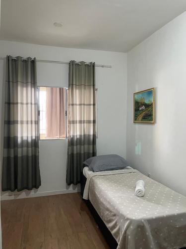 ein Schlafzimmer mit einem Bett und einem Fenster in der Unterkunft Casa da Lelê in Vila Velha