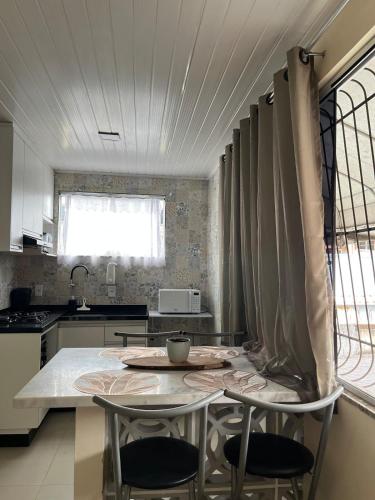 a kitchen with a table and two chairs in it at Casa da Lelê in Vila Velha