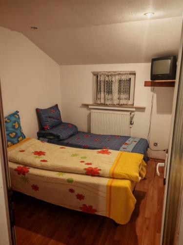a small bedroom with a bed and a television at Apartament muncitori in Bacău