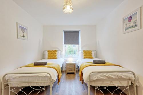 two beds in a room with white walls at Spacious 4BR Townhouse, Sleeps 9, Fast WIFI, FREE PARKING, Contractor friendly in Colchester