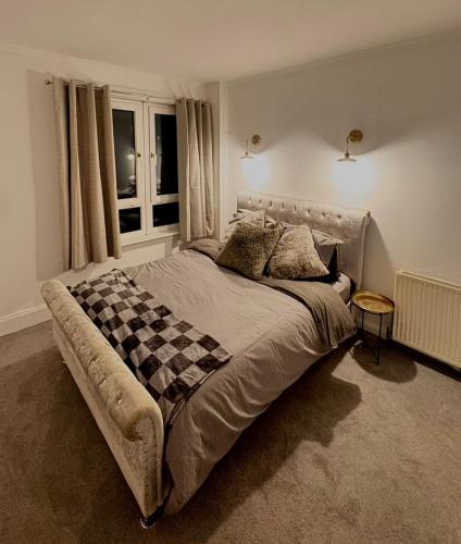 a bedroom with a large bed with a checkered blanket at Cozy corner-Sleeps 8 guest Entire house Glasgow very central in Glasgow
