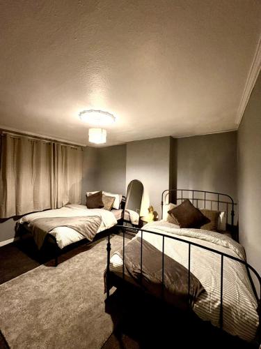 a bedroom with two beds and a window at Cozy corner-Sleeps 8 guest Entire house Glasgow very central in Glasgow