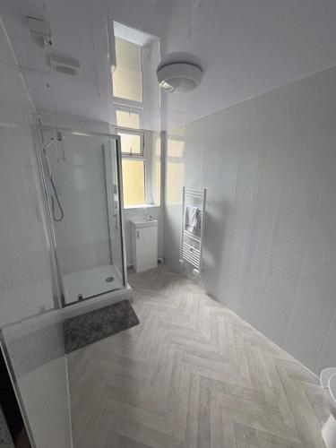 an empty room with a shower and a bathroom at Pentwyn avenue apartment in Mountain Ash