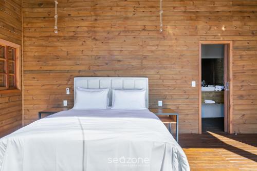 Cabana com vista Serra Catarinense VST023 في São Paulo dos Pinhais: غرفة نوم بها سرير وجدار خشبي