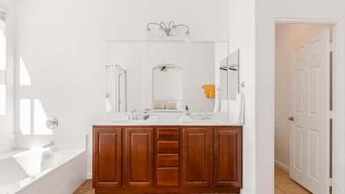 a bathroom with a sink and a mirror at Desert Oasis w Pool Spa BBQ Outdoor Dining Under the Palms Calle Tolosa by AvantStay in Desert Groves Mobile Home Park