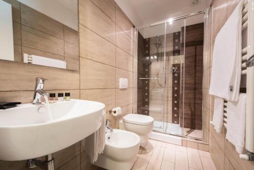 Isola Verde Resort في كاستيغليون ديل لاغو: حمام مع حوض ومرحاض