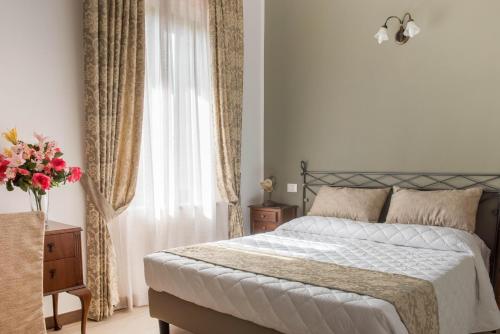 a bedroom with a bed and a vase of flowers at Isola Verde Resort in Castiglione del Lago