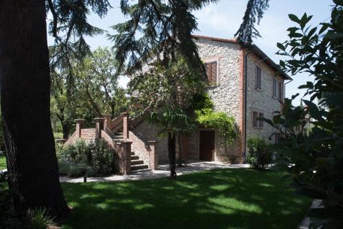 an exterior view of a stone house with a yard at Isola Verde Resort in Castiglione del Lago