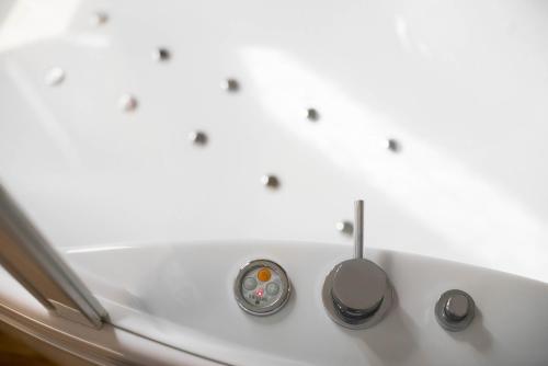 a bath tub with three faucets on it at Isola Verde Resort in Castiglione del Lago