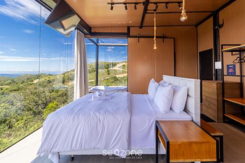 Un dormitorio con una cama y una ventana grande. en Cabaña romántica cerca de Florianópolis VST038, en São Paulo dos Pinhais