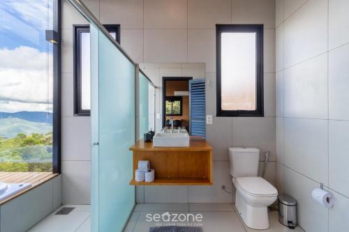 Charmoso chalé com lareira e hidro! VST034 في São Paulo dos Pinhais: حمام مع حوض ومرحاض ونافذة