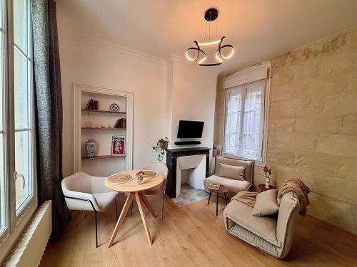 a living room with a table and chairs and a desk at Le Nid du Château - Cocon avec Bagagerie in Angers