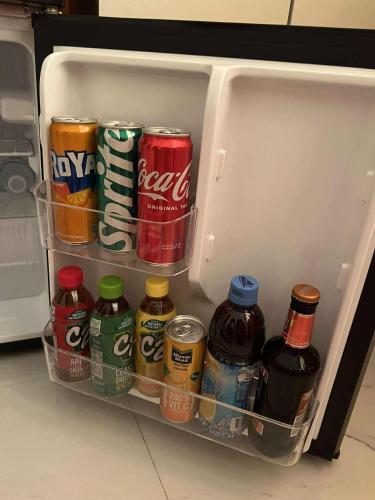 an open refrigerator filled with drinks and soda at Compostela Guest Room #3 Terrace, Rooftop, WiFi, Netflix in Compostela